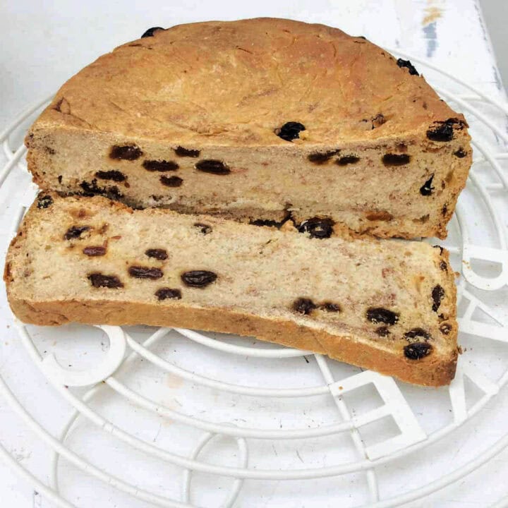 Sliced fruit bread loaf on a white table.