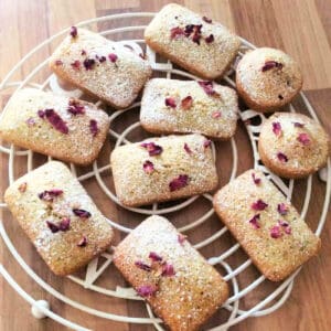 Rose and pistachio financiers on a cooling rack.