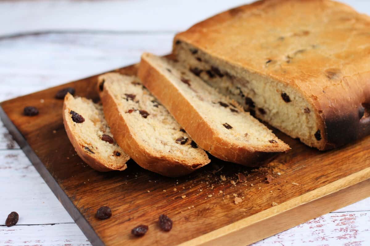 Loaf of raisin bread sliced open on a chopping board.