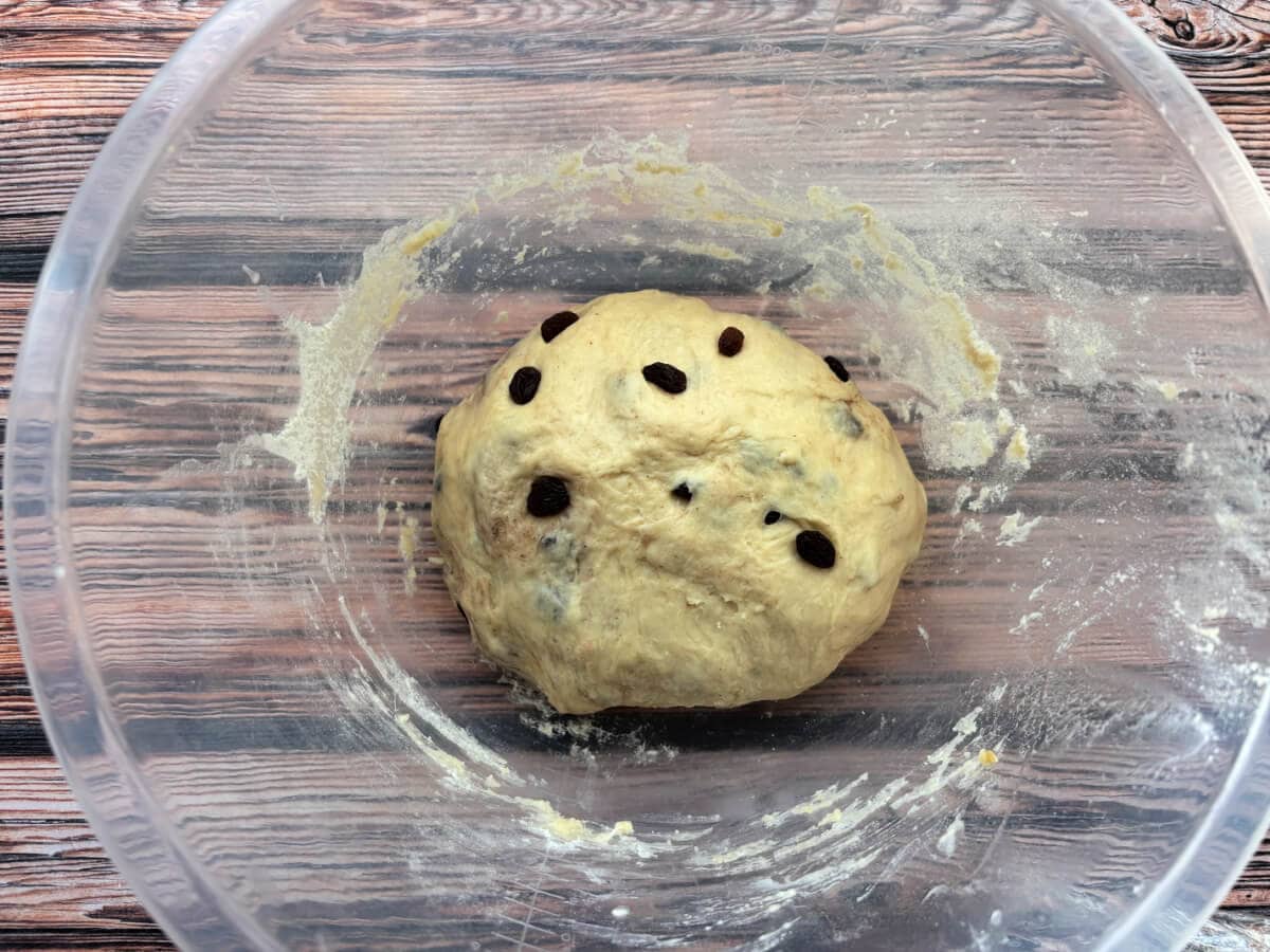 Dough with raisins added, in bowl.