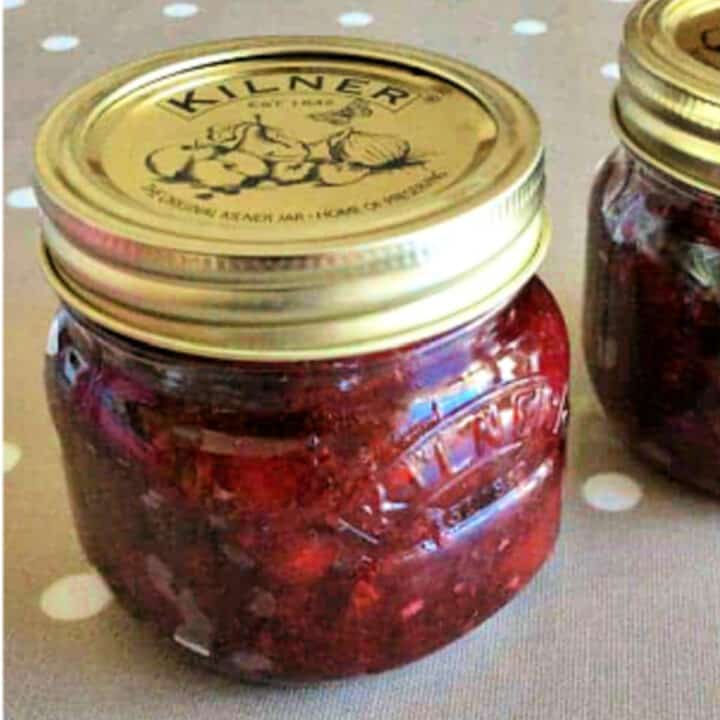 Close up of a small jar of red jam.