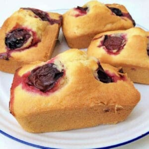 Mini loaf cakes with plum on a white plate.