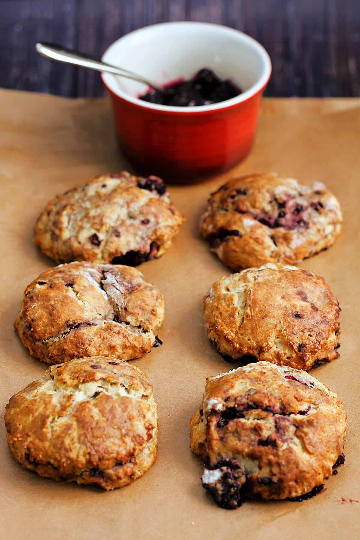 Six blackberry scones and a pot of jam.