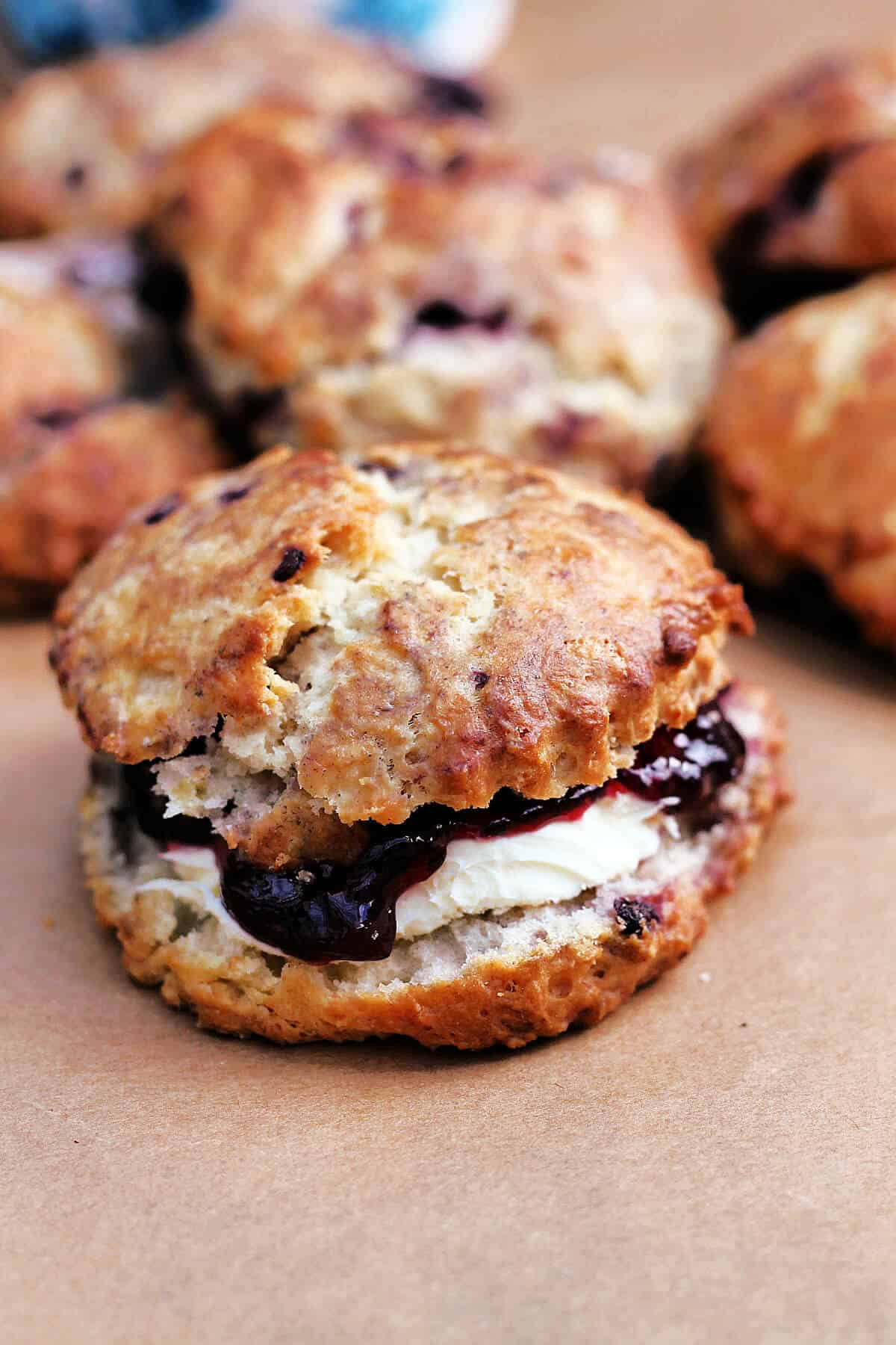 Close up of scone filled with clotted cream and jam.
