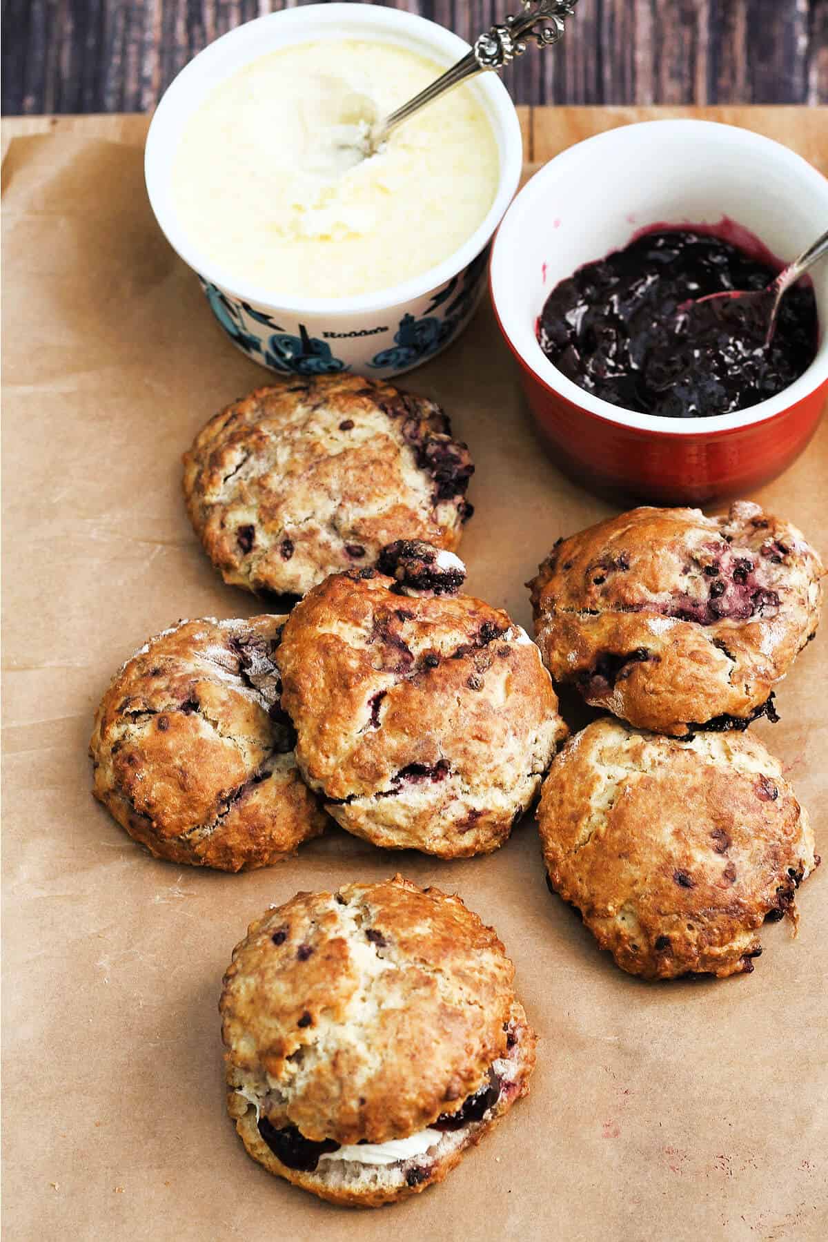 Scones with a tub of clotted cream and bowl of jam.