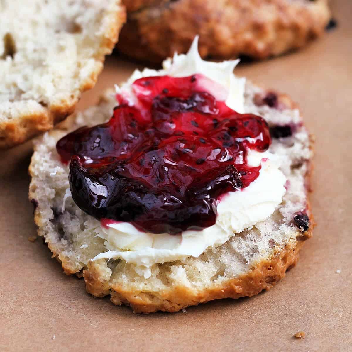Half a scone with blackberry jam and cream.