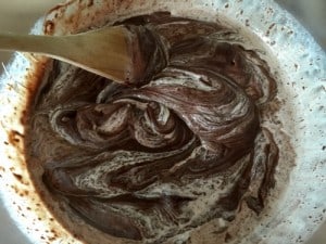 Making chocolate ganache, mixing together cream and chocolate.