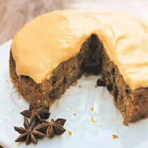 Cake with pumpkin frosting on cake board, with a slice removed, WITH TEXT OVERLAY.