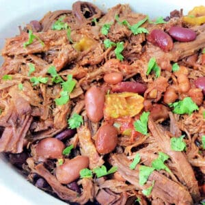 Bowl of brisket chilli with yellow chillis and cilantro.