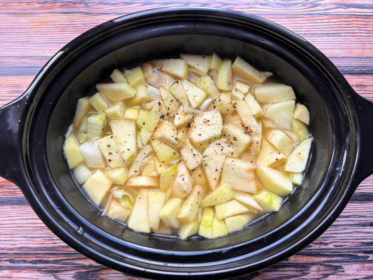 Soup ingredients in slow cooker pot.