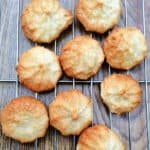 Almond petit four biscuits on a metal cooling rack.