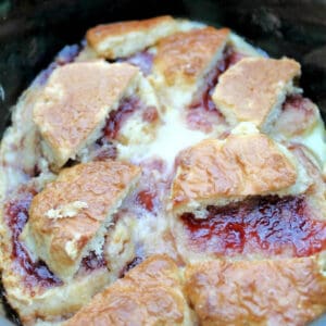 Jam and scone pudding in slow cooker pot.