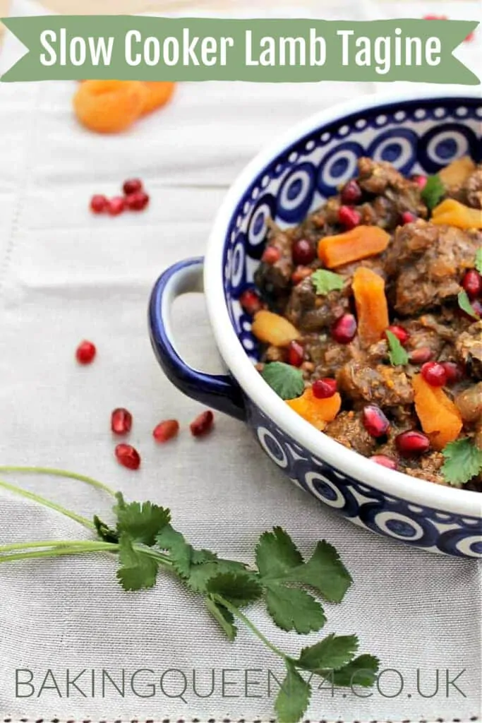 Lamb tagine served in a blue and white dish, with apricots, pomegranate seeds and flatleaf parsley, with text overlay (slow cooker lamb tagine).
