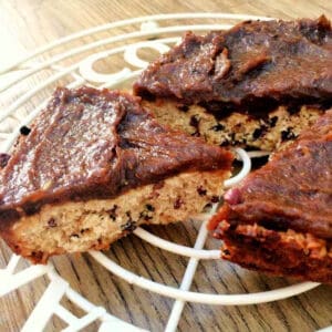 Oat slice with date caramel topping on a white cooling rack.