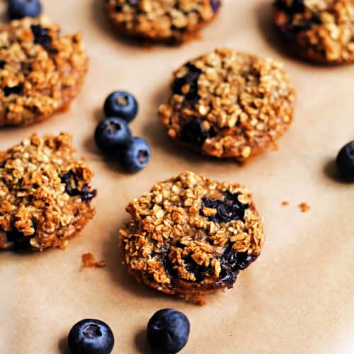 Mini cinnamon and blueberry baked oat cups, with fresh blueberries.