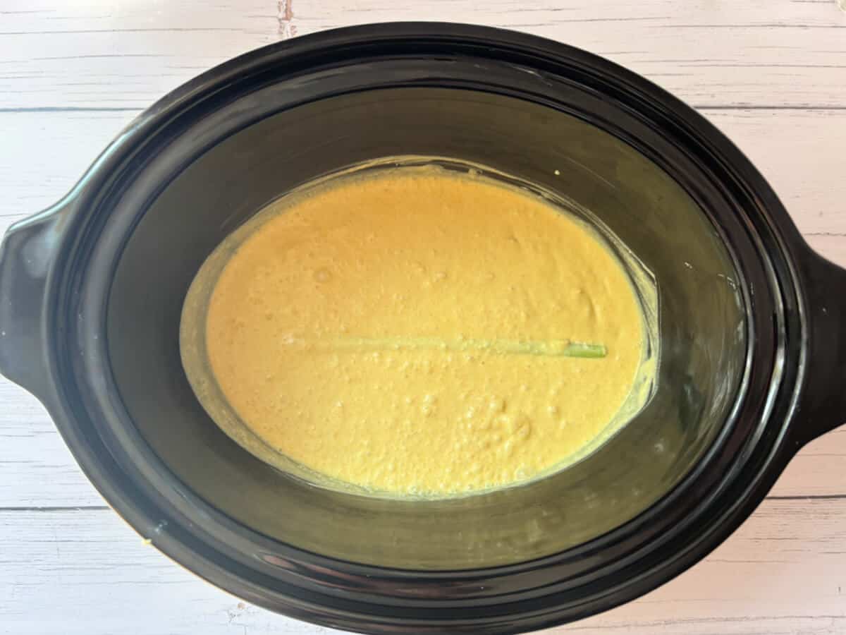 Coconut milk sauce in slow cooker pot.