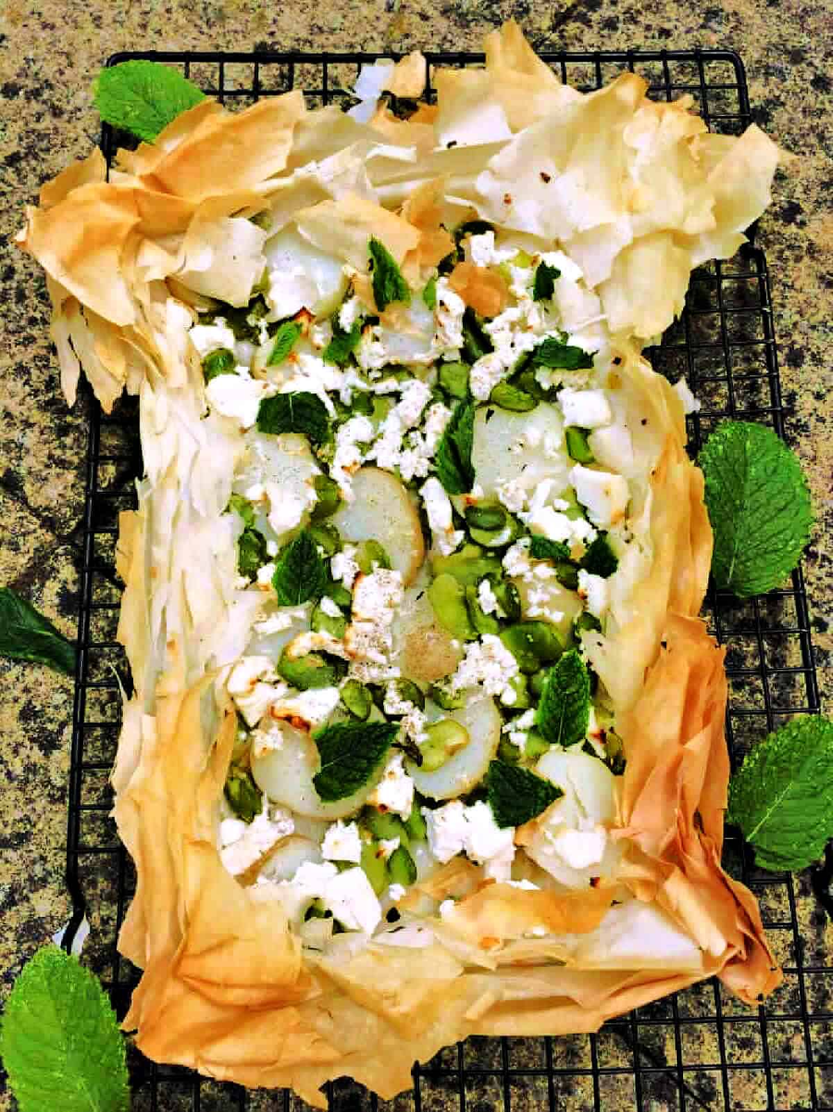 Broad bean filo tart with mint leaves.