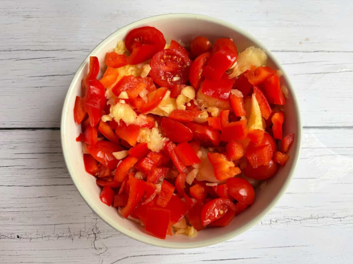 Courgette flesh, chopped pepper and halved cheery tomatoes in a bowl.