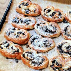 Palmiers dusted with icing sugar on tray.