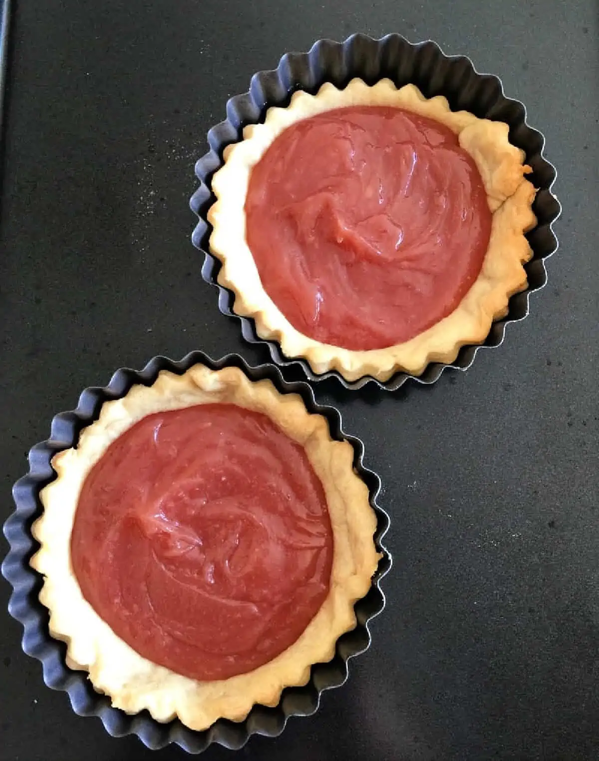 Two tart shells filled with pink curd.
