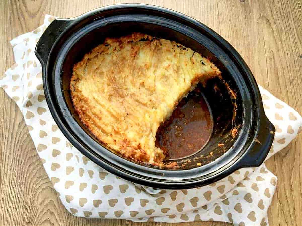 Overhead view of cottage pie with mashed potato topping in slow cooker pot.