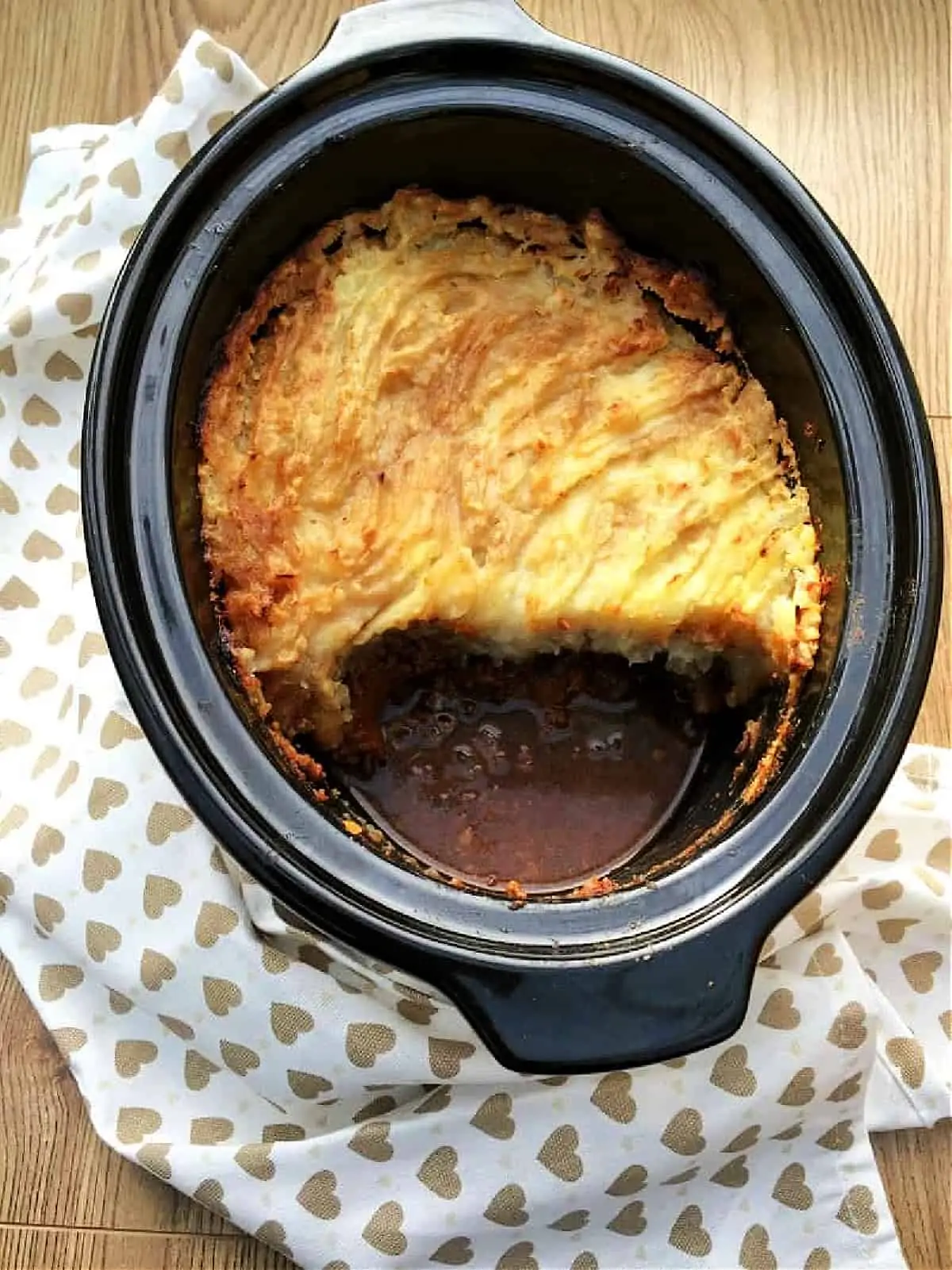 Overhead view of cottage pie with mashed potato topping in slow cooker pot.
