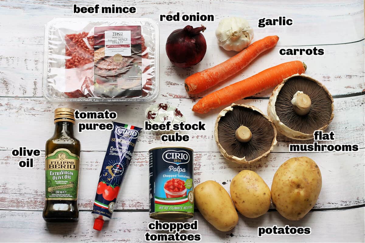Labelled cottage pie ingredients on white table.