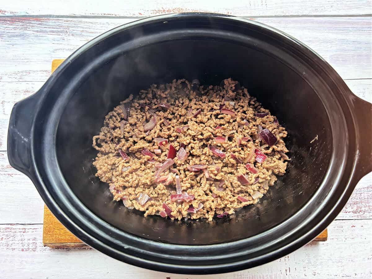 Minced beef mixture in slow cooker pot.