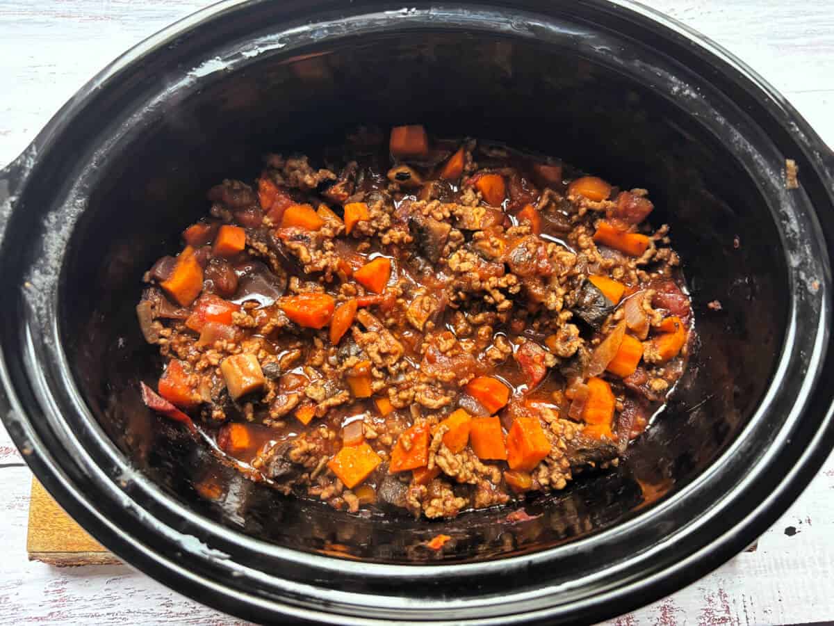 Cooked cottage pie filling in slow cooker pot.