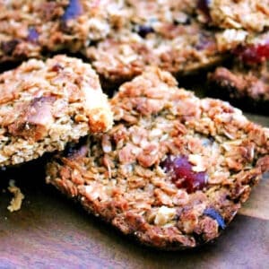 Squares of cherry flapjack on wooden board.