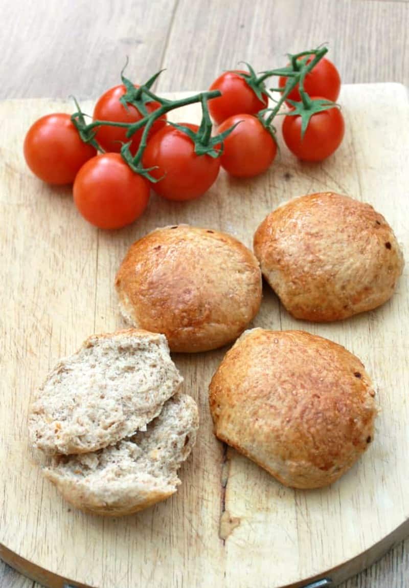 Wholemeal chilli rolls on a board with tomatoes