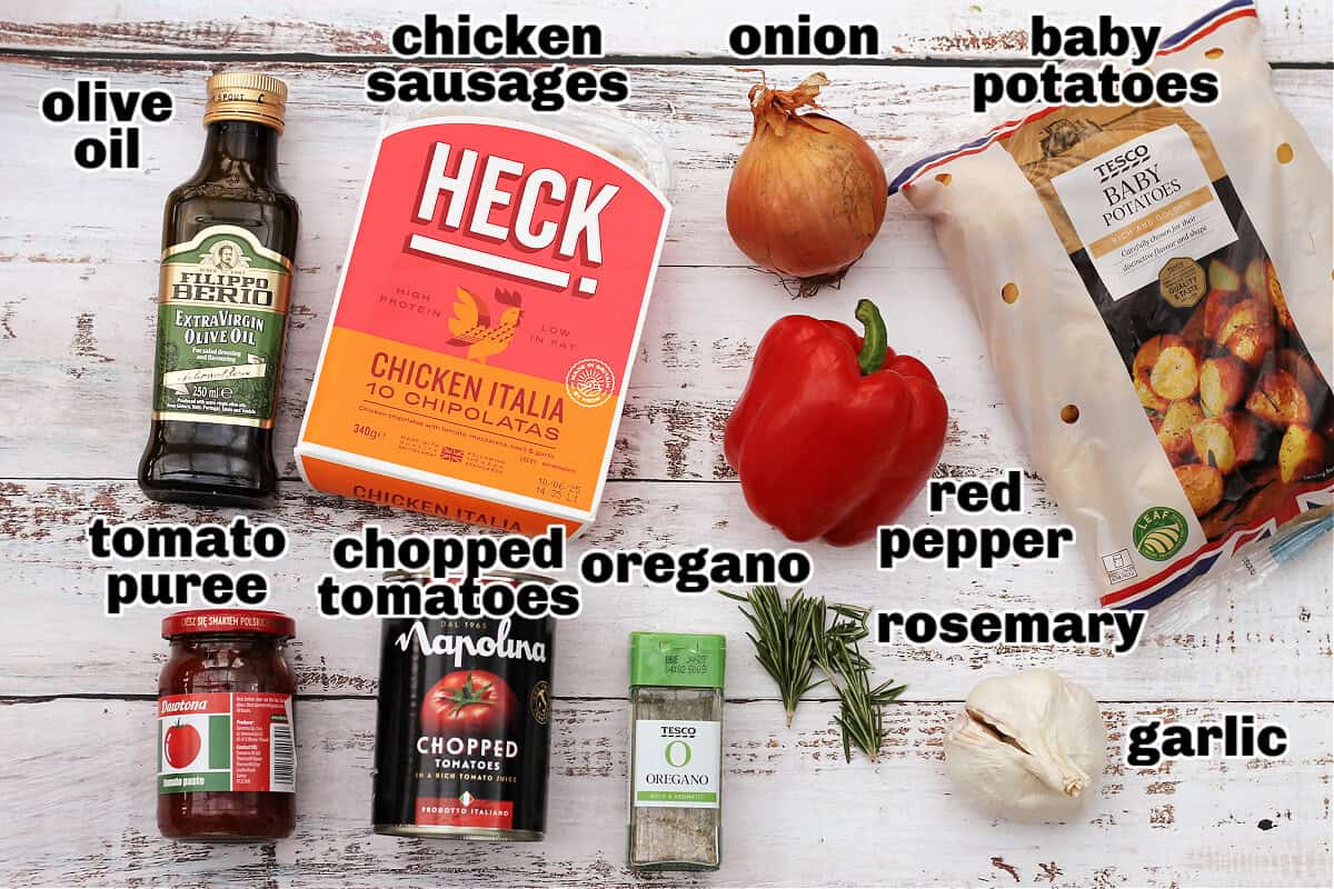 Labelled ingredients for chicken sausage bake laid out on white table.