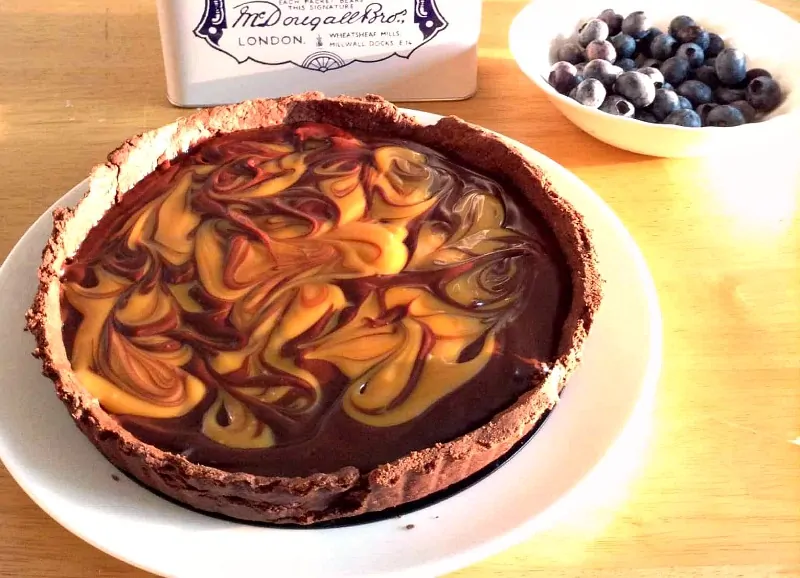 Chocolate salted caramel tart served on a table, close up