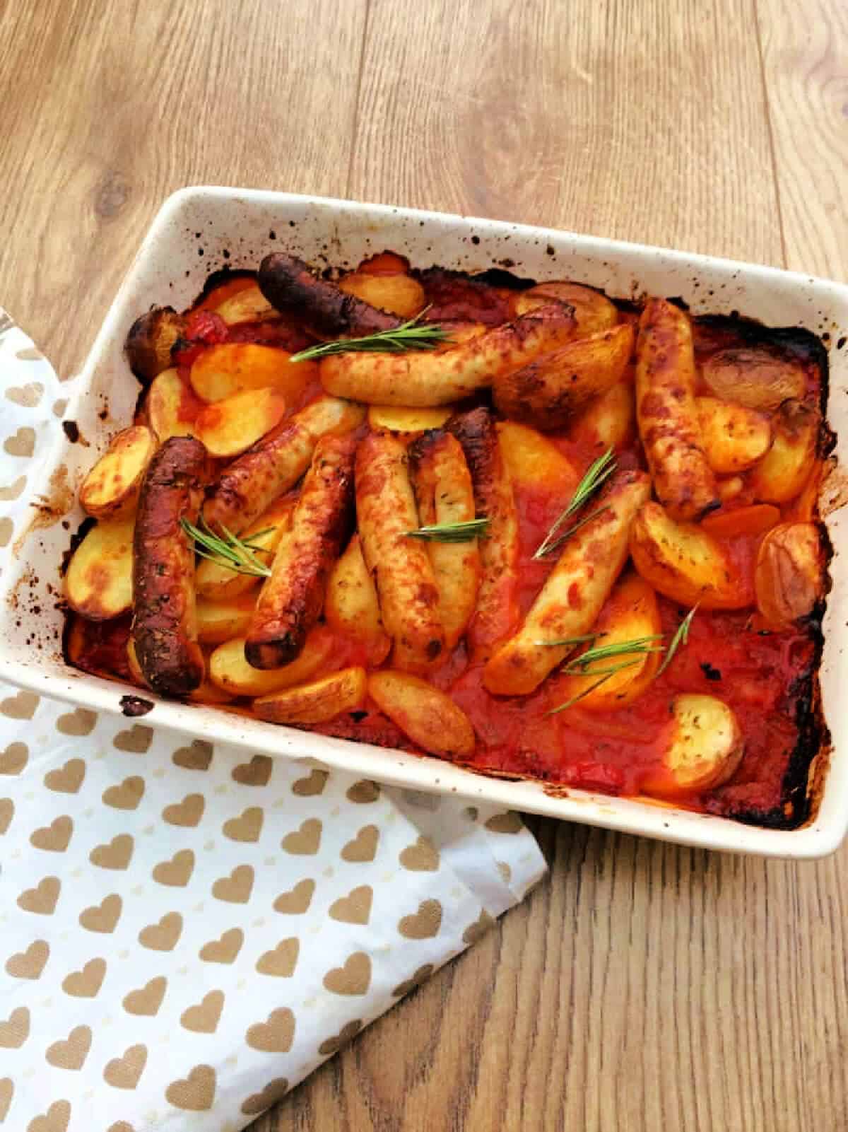 Chicken sausage and potato bake in a white serving dish.