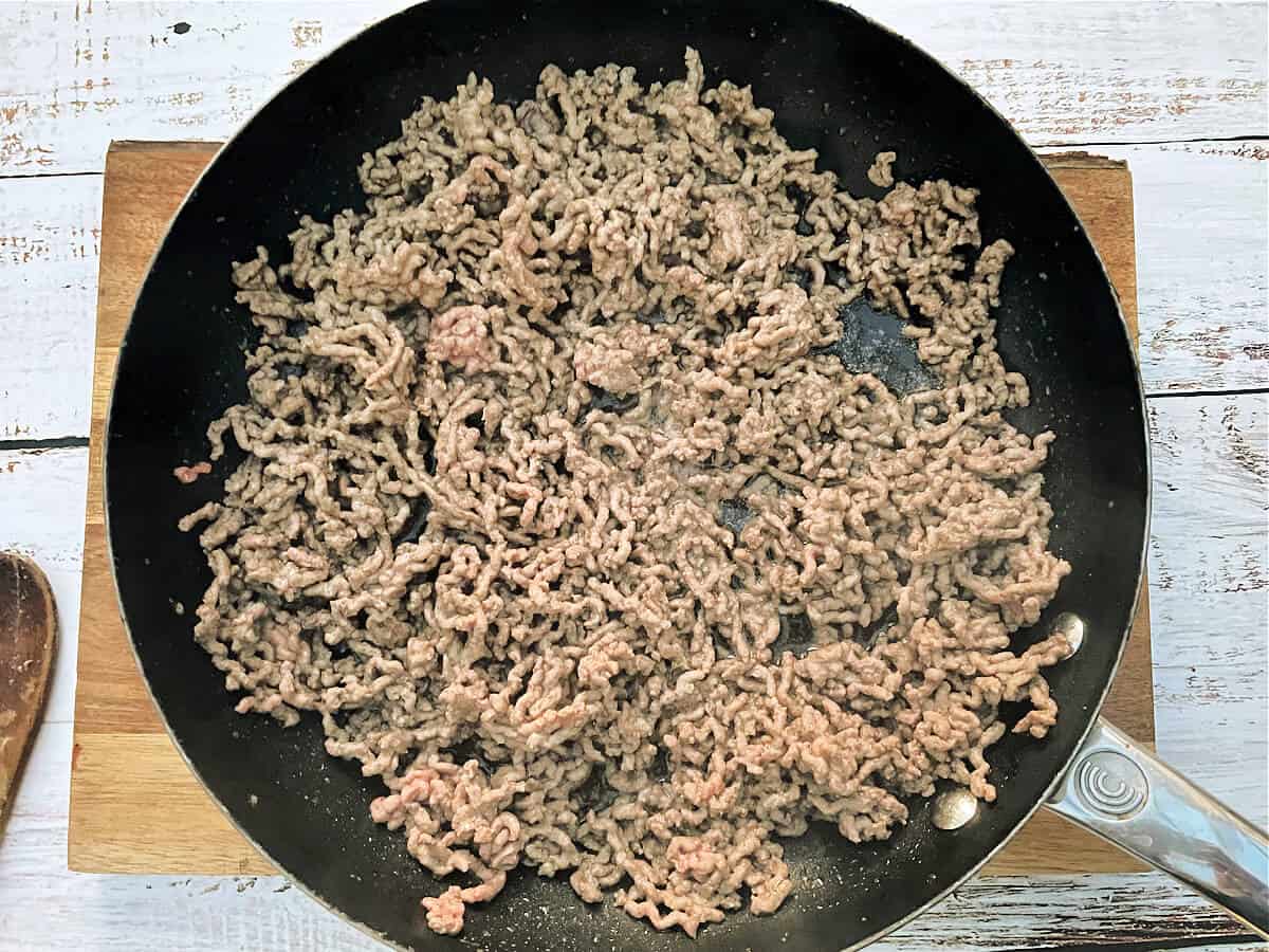 Frying pan with browned beef mince in it.