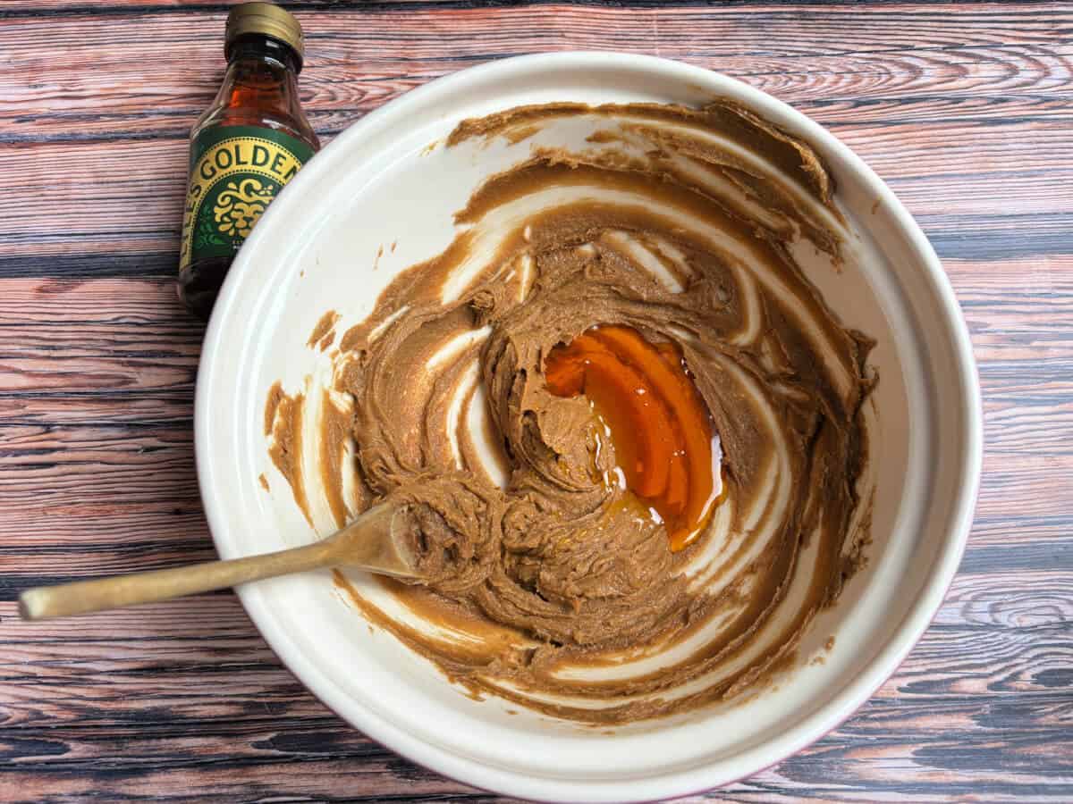 Creamed butter and sugar with golden syrup, in a bowl with wooden spoon.