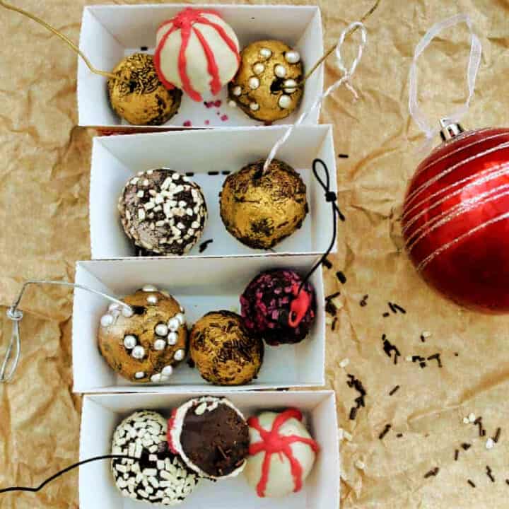 Chocolate truffles decorated as baubles in small cardboard trays.