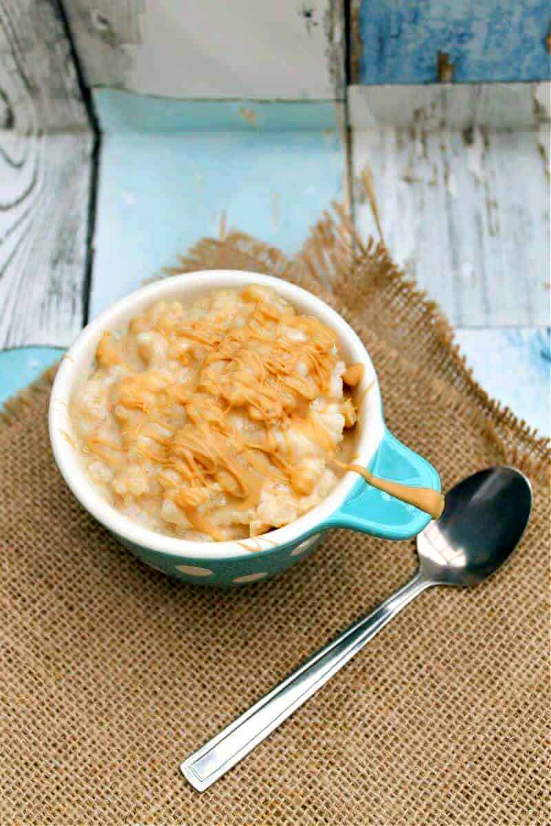 Rice pudding in a serving bowl on blue toned background with hessian.