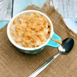 Bowl of rice pudding with spoon on a piece of hessian.
