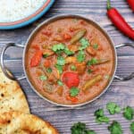 Close up of lamb curry in serving dish, garnished with coriander.