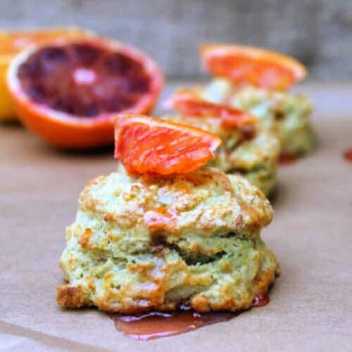 Scones with blood orange syrup topped with blood orange pieces.