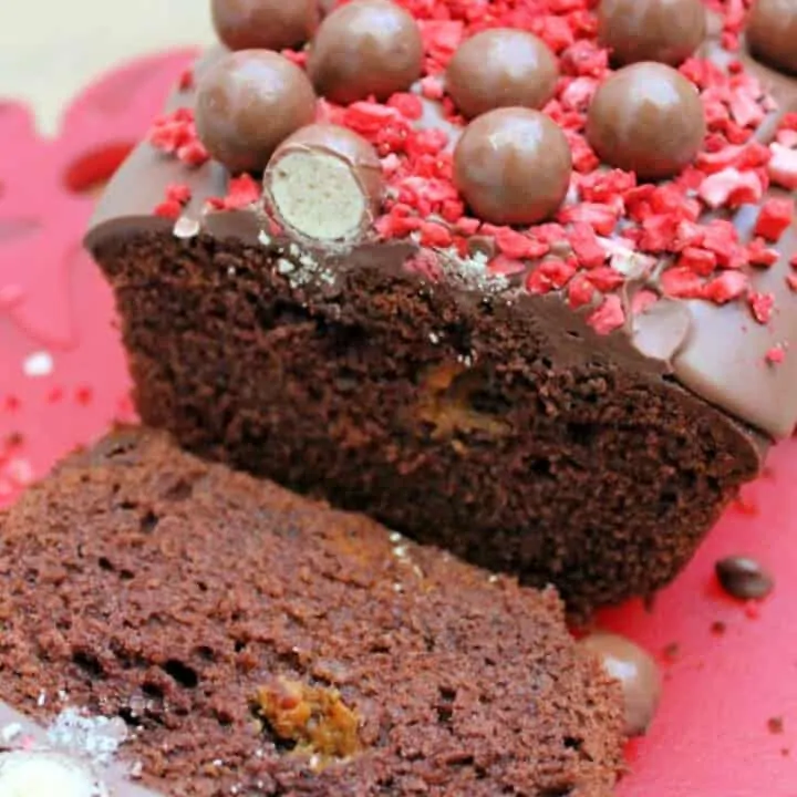 Close up of sliced open chocolate cake topped with Maltesers.