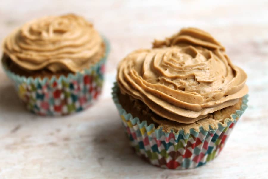 Two cupcakes with icing, in colourful cupcake cases.