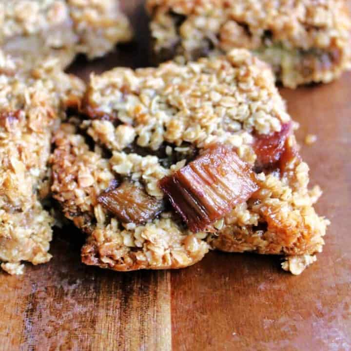 Flapjack with chunks of rhubarb on wooden board.