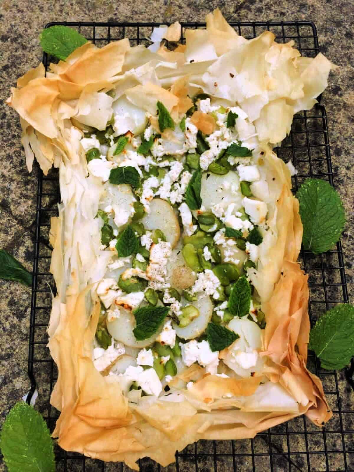 Broad bean filo tart with mint leaves.