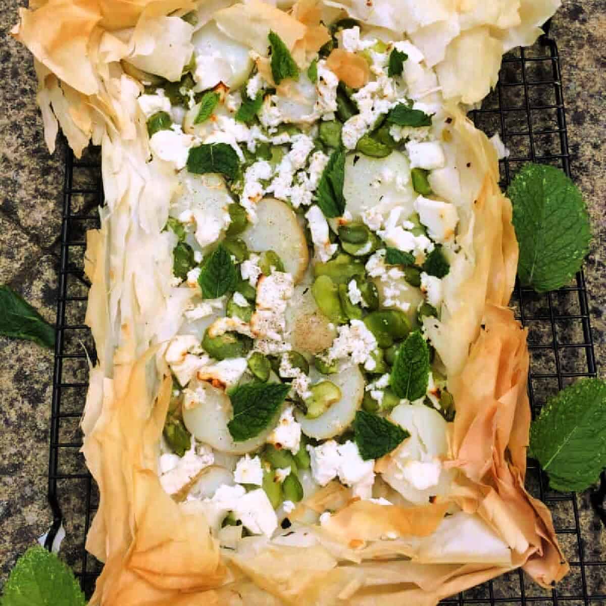 Broad bean filo tart with mint leaves.