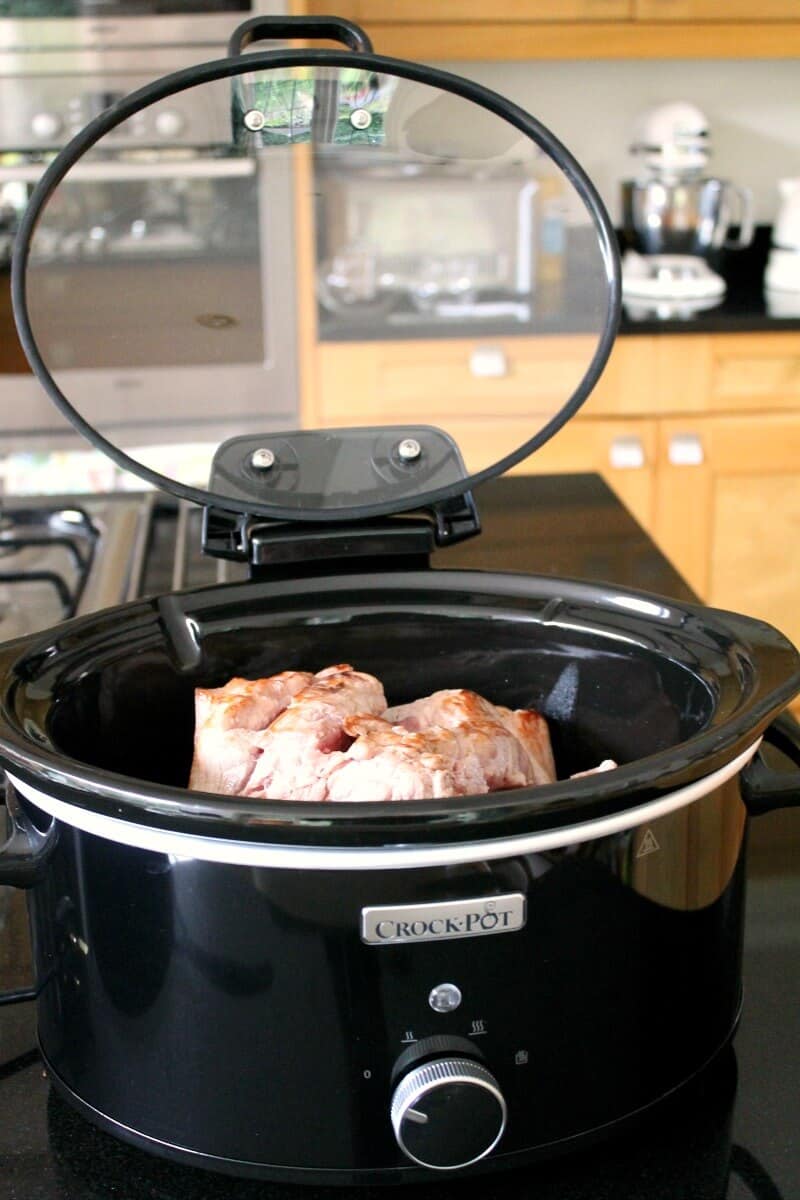 Adding the pork to the crockpot for paprika pork goulash