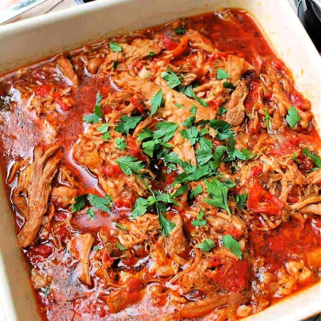 Shredded pork with peppers in a white serving dish.