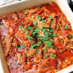 Shredded pork with peppers in a white serving dish.