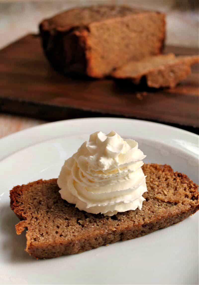 Slow cooker sticky ginger cake with whipped cream, served on a plate